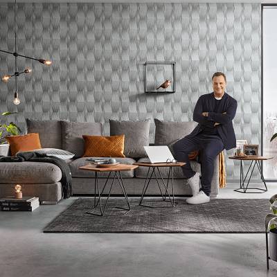 Stylischer Wohnbereich mit Guido Maria Kretschmer vor Designertapete in 3D Optik bei Heineking24